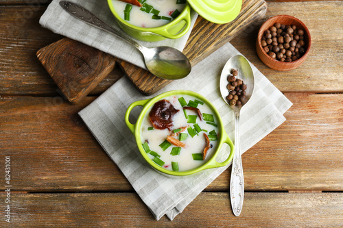 Mushroom soup on wooden table with napkin, top view