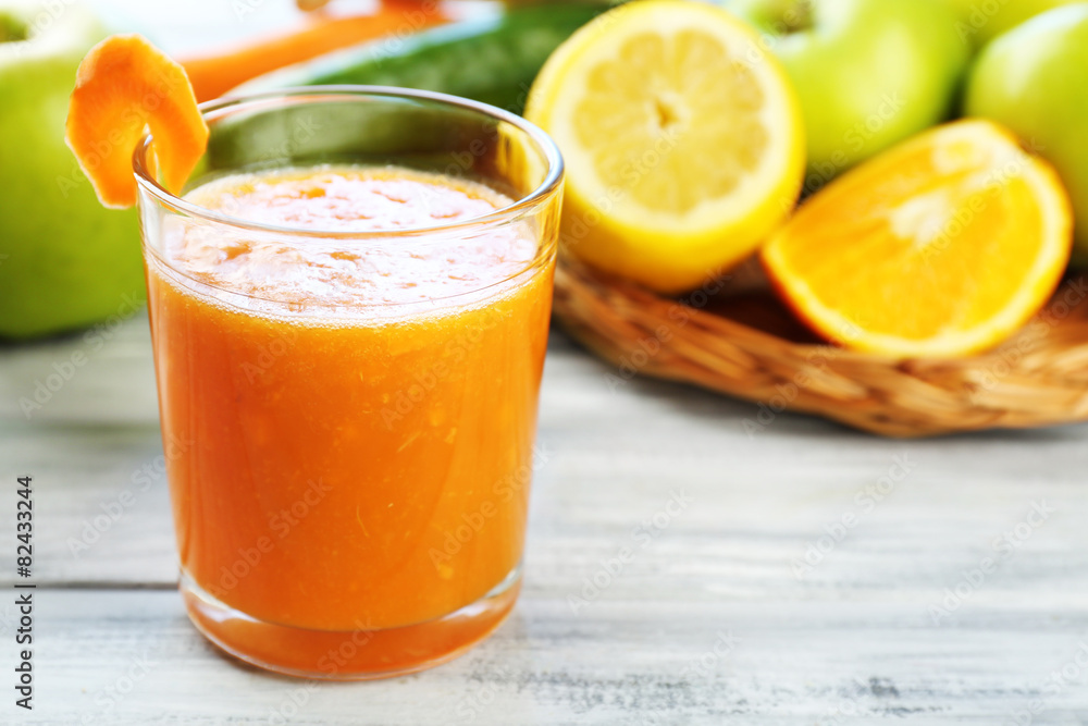 Glass of fresh juice, fruits and vegetables on wooden table, on bright background Glass of fresh juice, fruits and vegetables on wooden table, on bright background