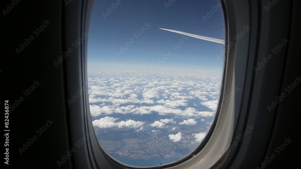 Clouds seen through the window of jet airplane. Airplane flies above the weather Clouds seen through the window of jet airplane. Airplane flies above the weather