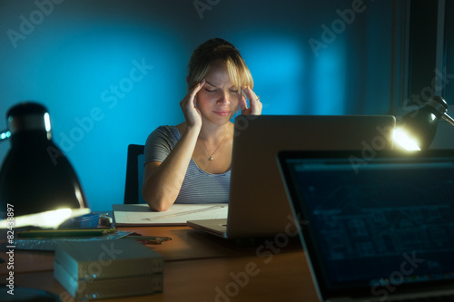 Woman With Eyes Tired Working Late At Night In Office photo