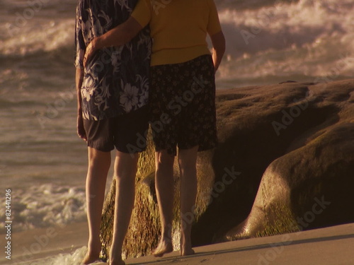 Rear view of chubby couple walking on beach