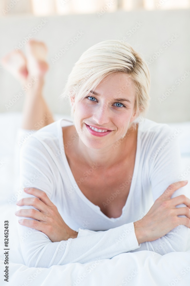 Smiling blonde woman lying on the bed Smiling blonde woman lying on the bed