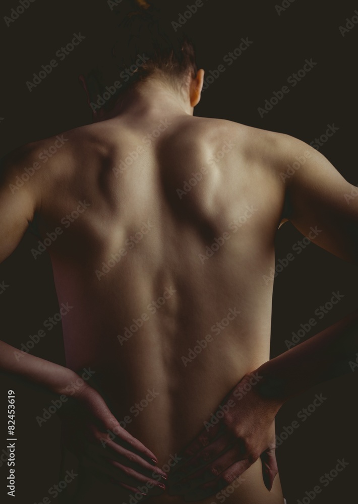 Nude woman with a back injury