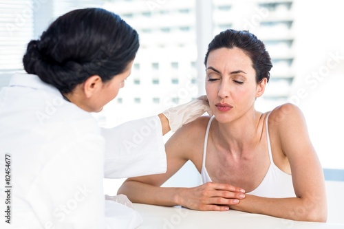 Quadro su tela Doctor examining her patients neck