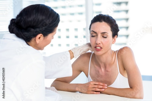 Doctor examining her patients neck