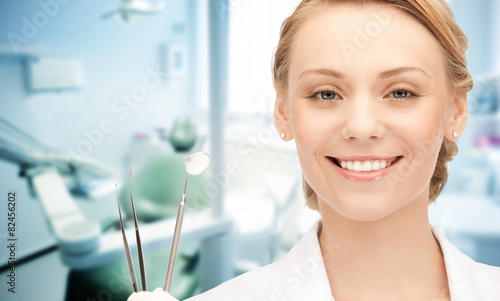 happy young female dentist with tools