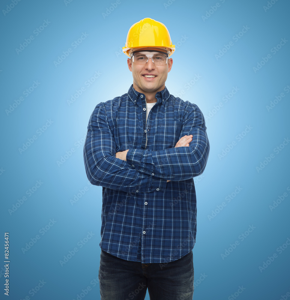smiling male builder or manual worker in helmet