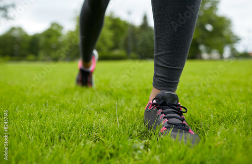 close up of exercising woman legs on grass in park