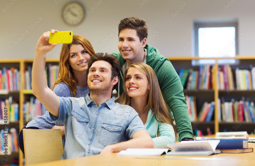 students with smartphone taking selfie in library students with smartphone taking selfie in library