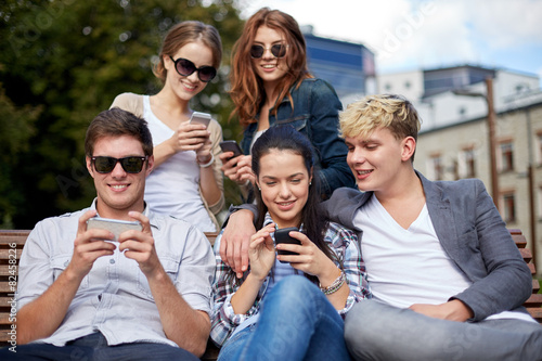 students or teenagers with smartphones at campus