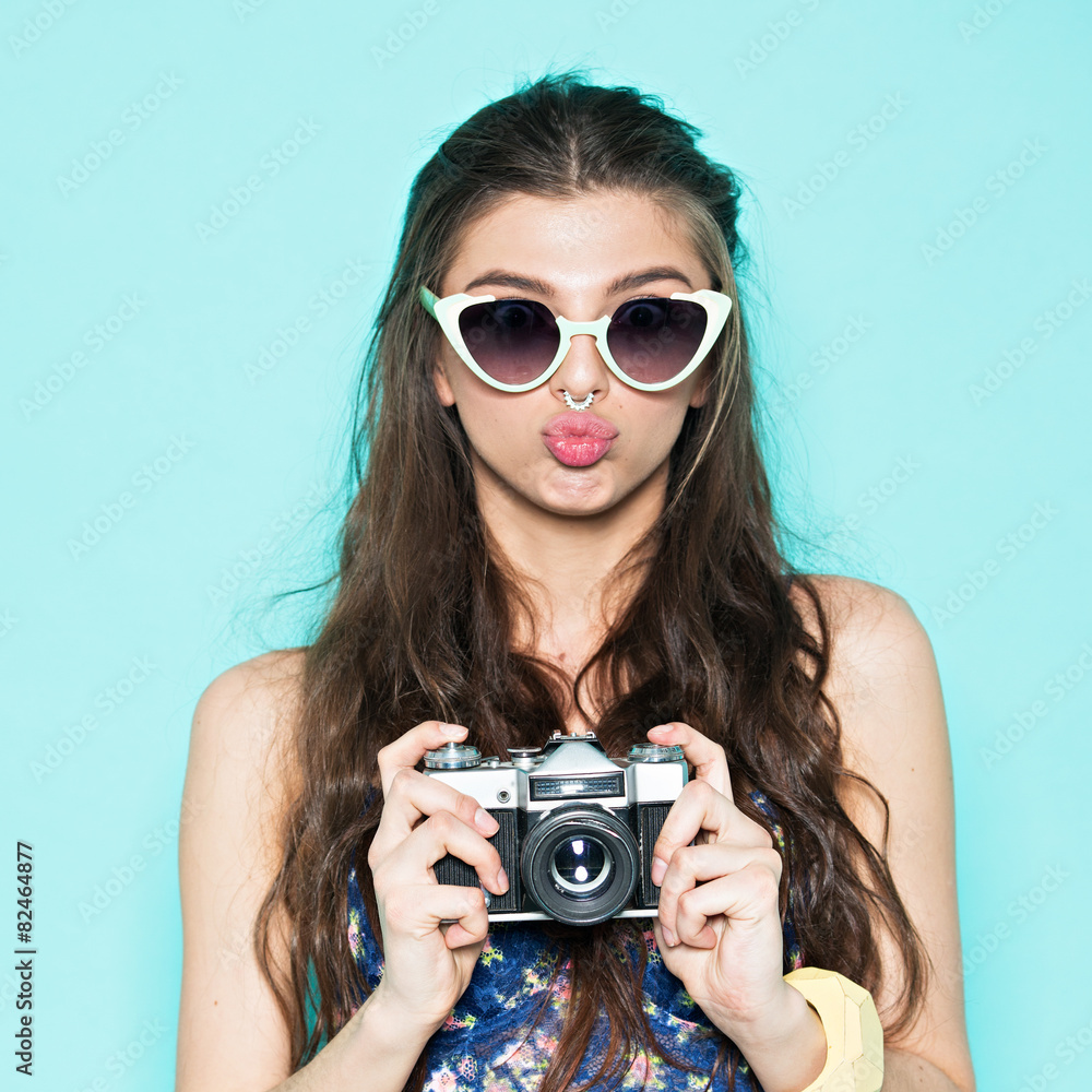 Hipster woman taking photos with retro film camera on the field