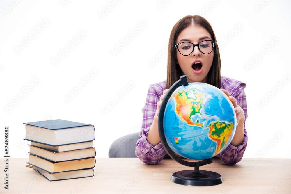 Amazed young female student looking at globe Amazed young female student looking at globe