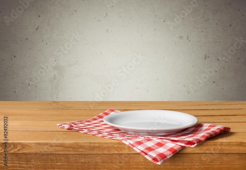 Plate. Empty white plate on wooden table over red grunge