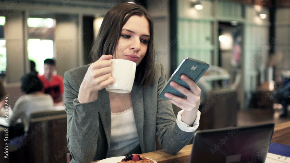 businesswoman using smartphone and drinking coffee in cafe businesswoman using smartphone and drinking coffee in cafe