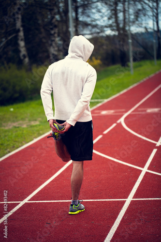 Single man in white swetshirt stretching befor run