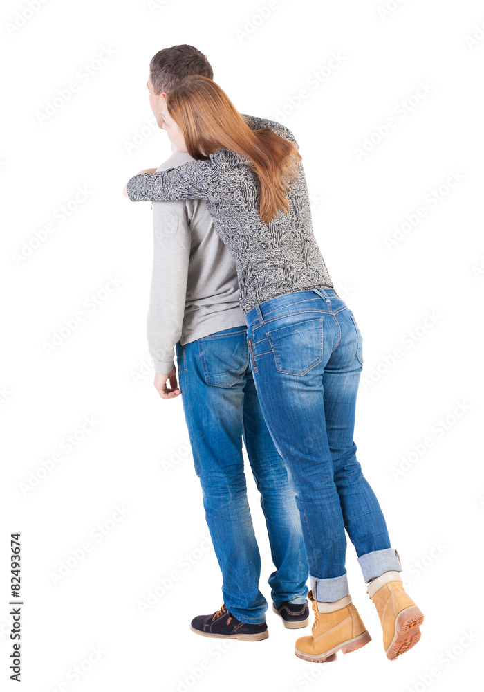 Back view of young embracing couple (man and woman) hug and look Back view of young embracing couple (man and woman) hug and look