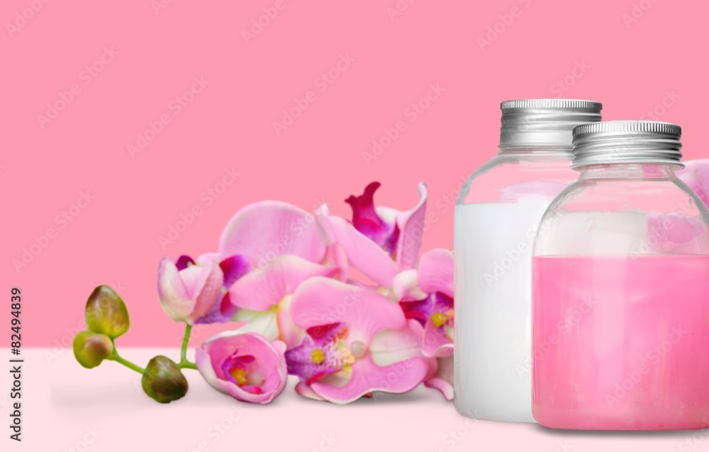 Cosmetics. Pink soap bottles and flowers
