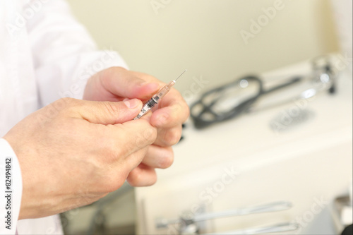 sirynge in doctors hands ready to make an injection photo