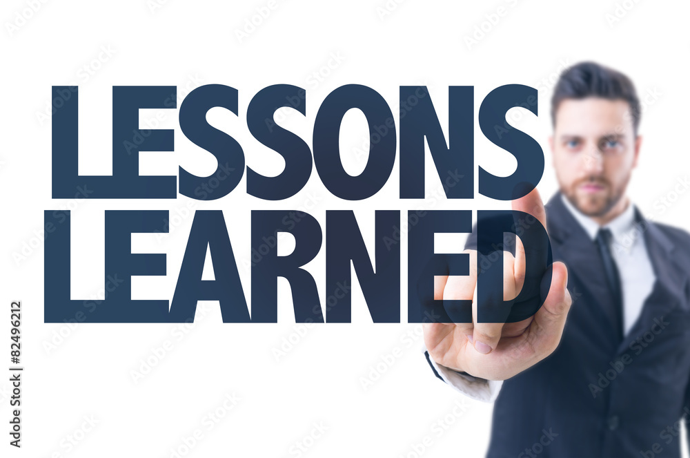 Business man pointing the text: Lessons Learned Business man pointing the text: Lessons Learned