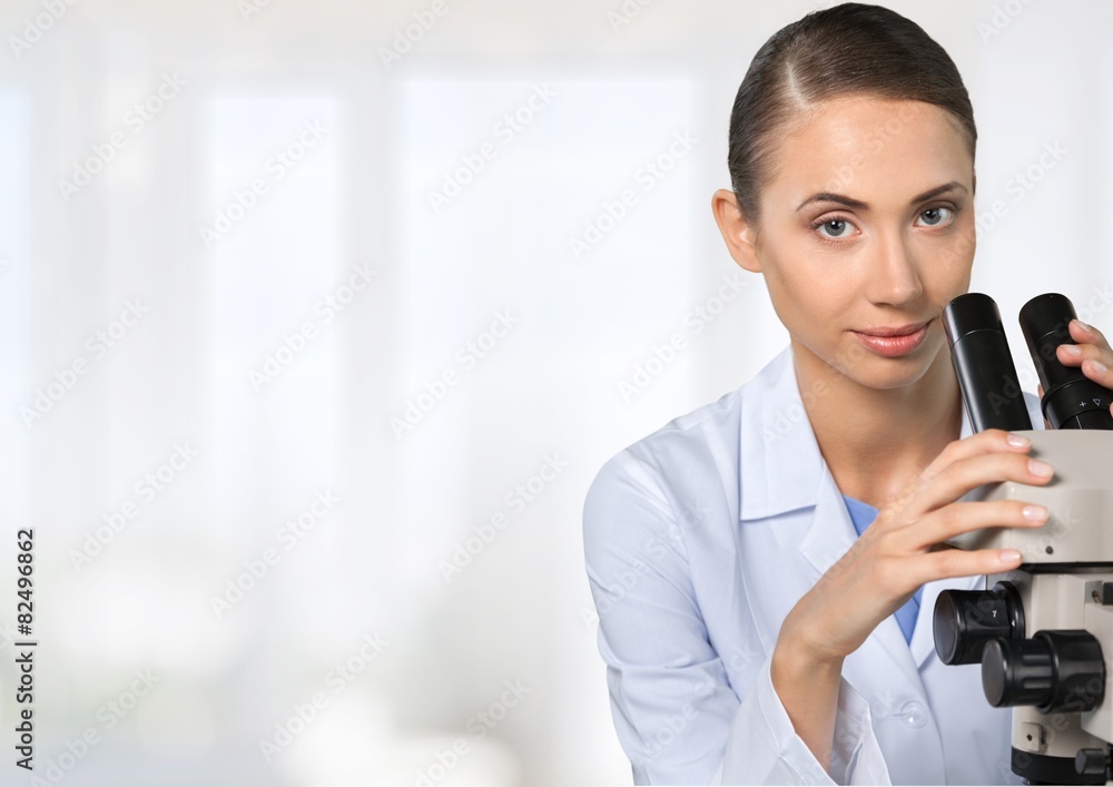 Fototapeta premium Microscope. Female researcher looking through microscope