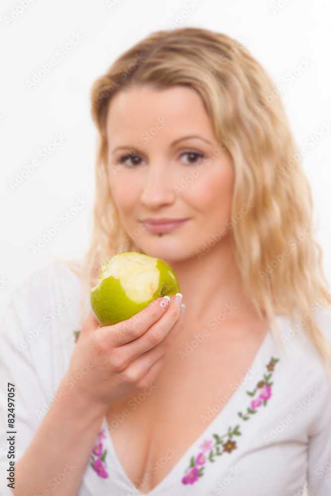 blurred face of young woman biting an apple blurred face of young woman biting an apple