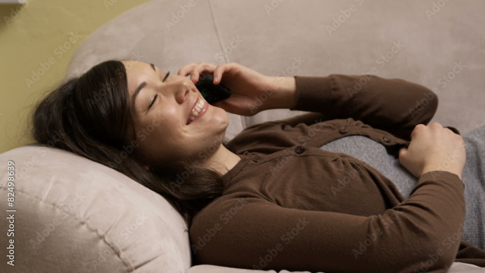 young woman talking on the phone on a couch young woman talking on the phone on a couch