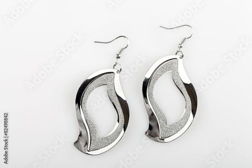 Pair of silver earrings on white background