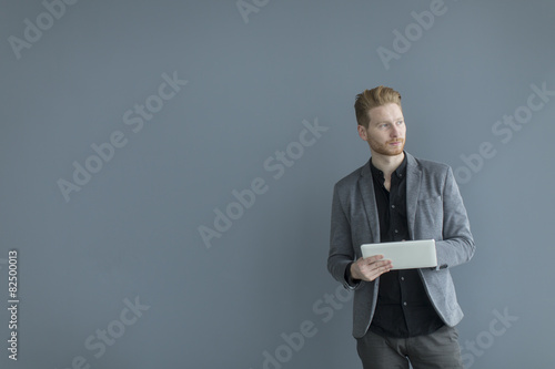 Man with tablet by the wall
