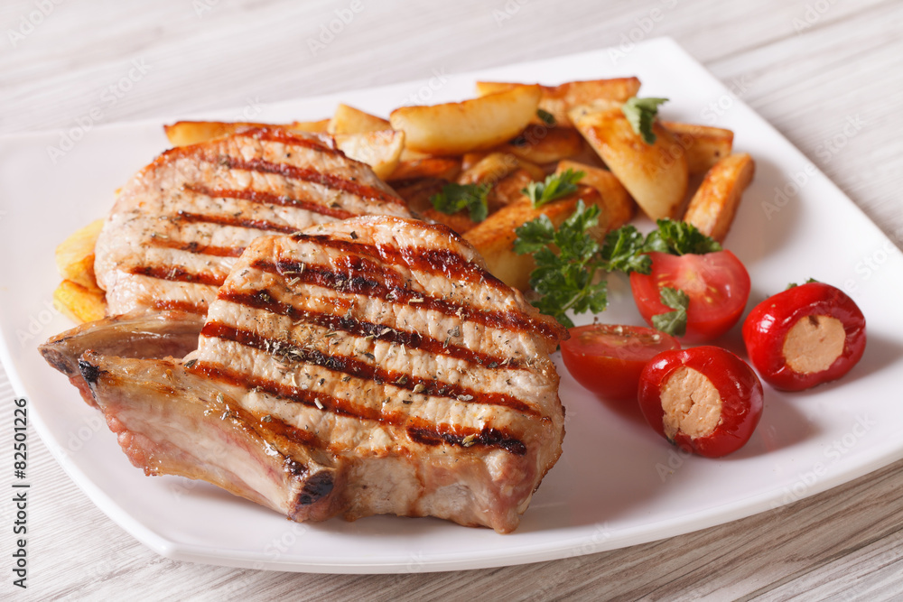 Grilled pork steak with potatoes and vegetables on a plate
