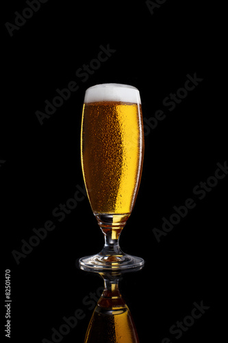 Glass of light beer isolated on a black background.
