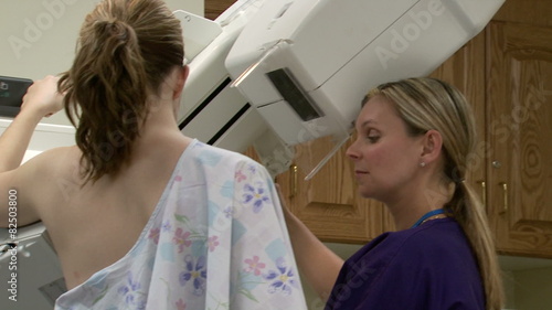 Nurse talking to female patient having mammogram