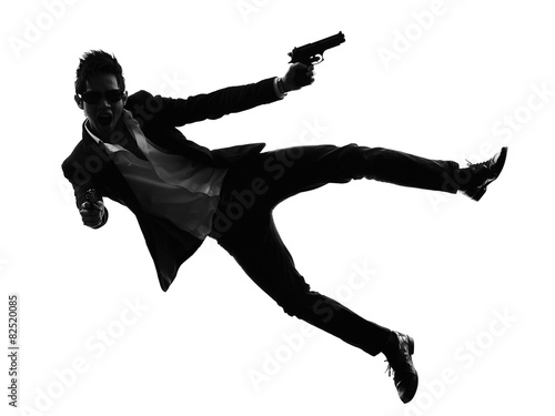 Fototapeta Naklejka Na Ścianę i Meble -  asian gunman killer jumping shooting  silhouette