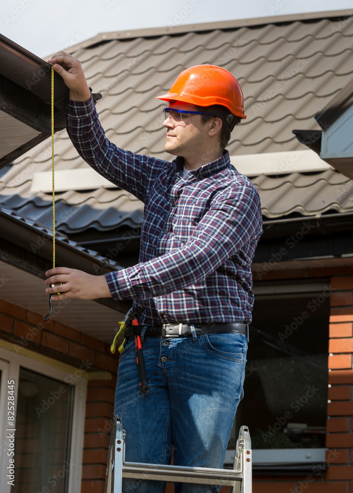 professional worker measuring height of roof with tape professional worker measuring height of roof with tape
