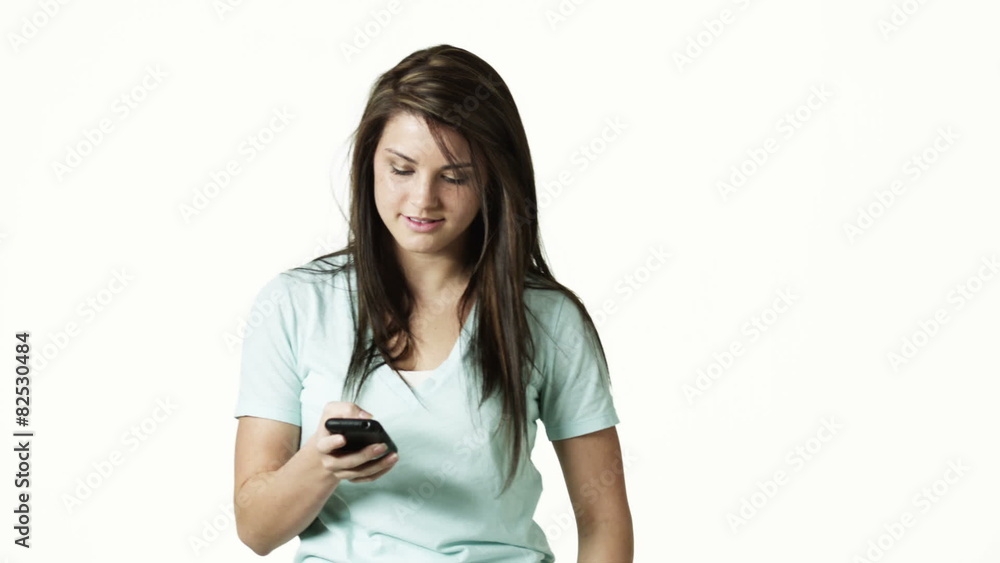 MS Portrait of young woman text-messaging against white background / Orem, Utah, USA MS Portrait of young woman text-messaging against white background / Orem, Utah, USA