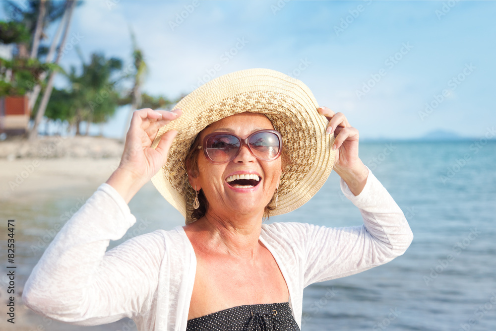 Happy mature woman of 50 years on the beach