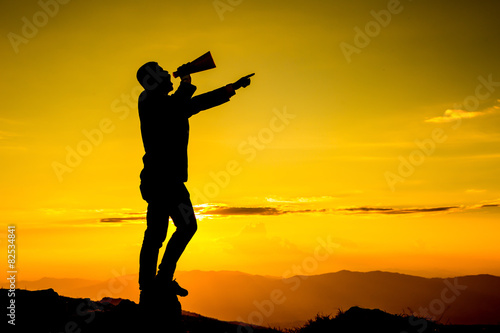 Businessman shouting for announce through a red loudspeaker