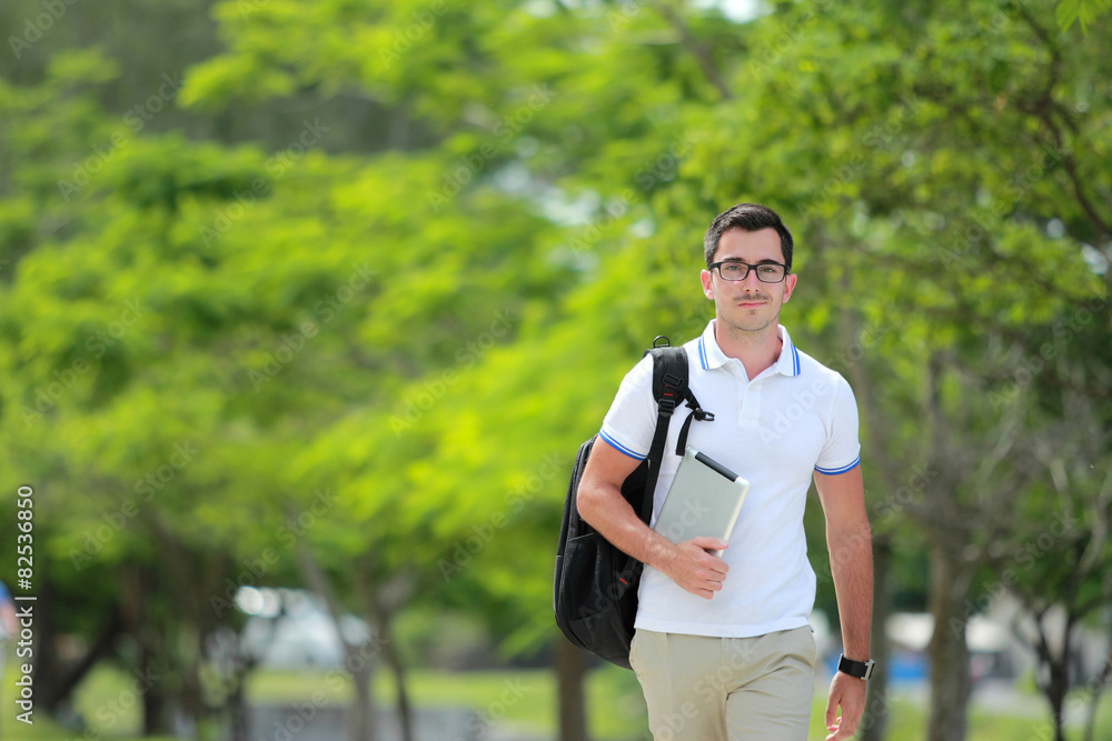 Naklejka premium college student walking by at college park