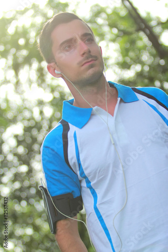 sporty man wearing earphone to listening music during jogging © Odua Images