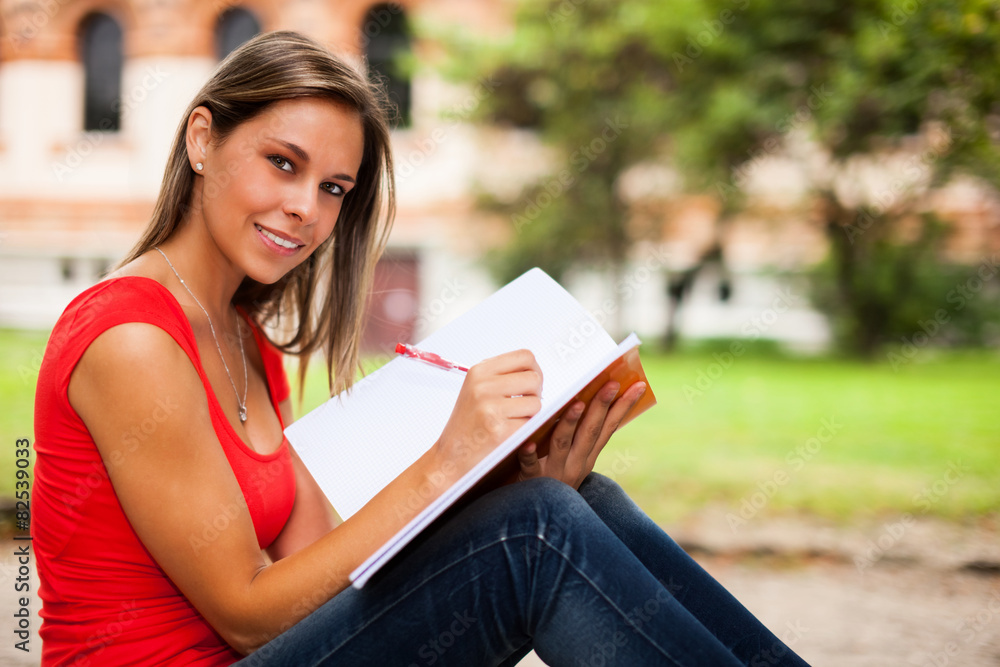 Obraz premium Young woman studying outdoors