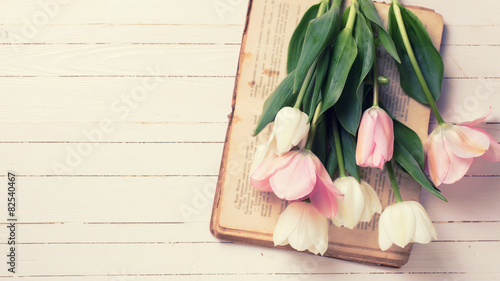 Fototapeta Naklejka Na Ścianę i Meble -  Background with fresh  tulip flowers on old book