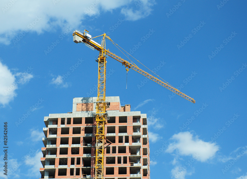 Construction site crane with clouds and blue sky background Construction site crane with clouds and blue sky background