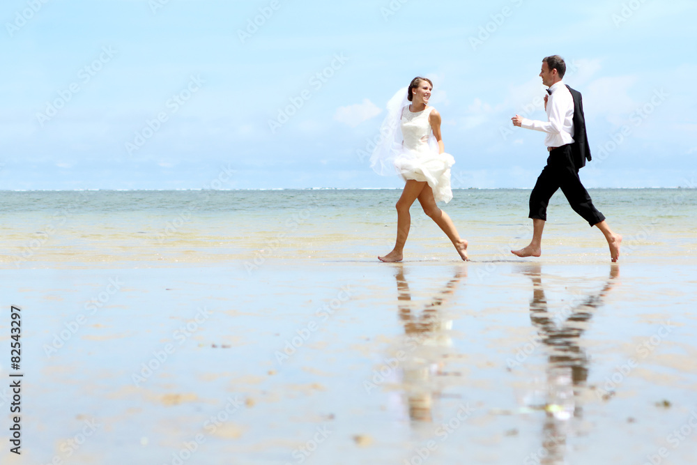 bride and groom playfully at the beach