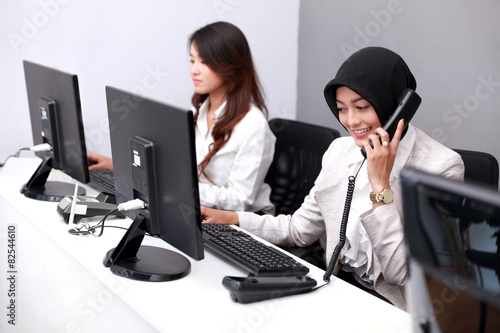 young businesswoman answering the telephone while working using