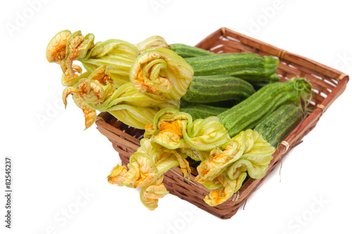 Courgettes with flowers in brown basket isolated photo