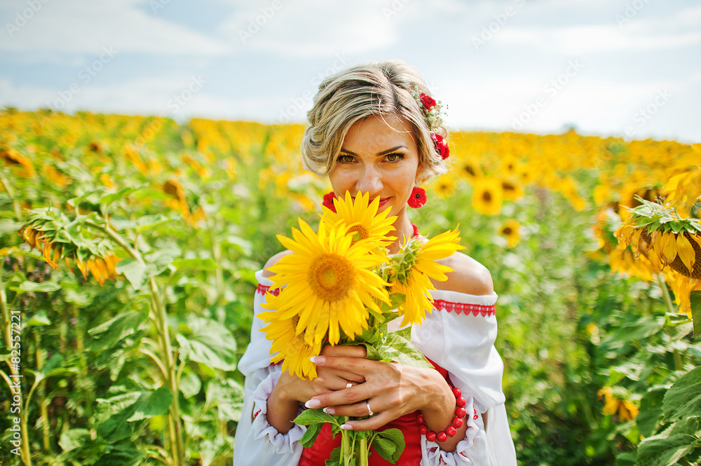 Fototapeta premium beautiful bride in traditional dress at the sunflower