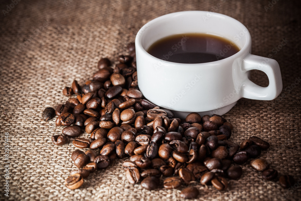 Fototapeta premium Coffee cup on coffee beans