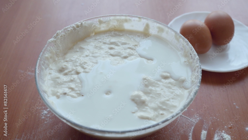 Milk flowing into the dough and Hands mixing fresh Dough Milk flowing into the dough and Hands mixing fresh Dough