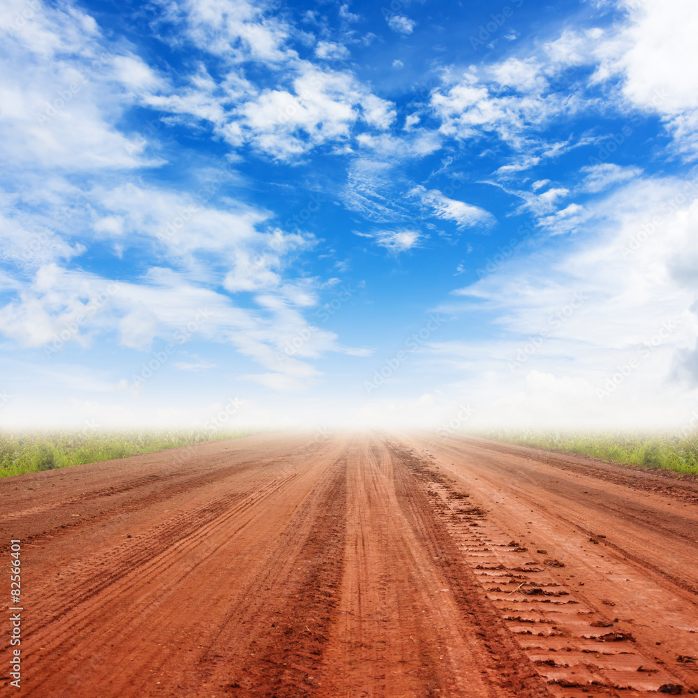 Naklejka premium rural road and blue sky with clouds