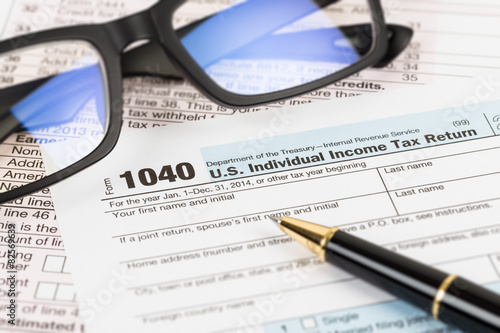 Tax form with glasses, and pen taxation concept