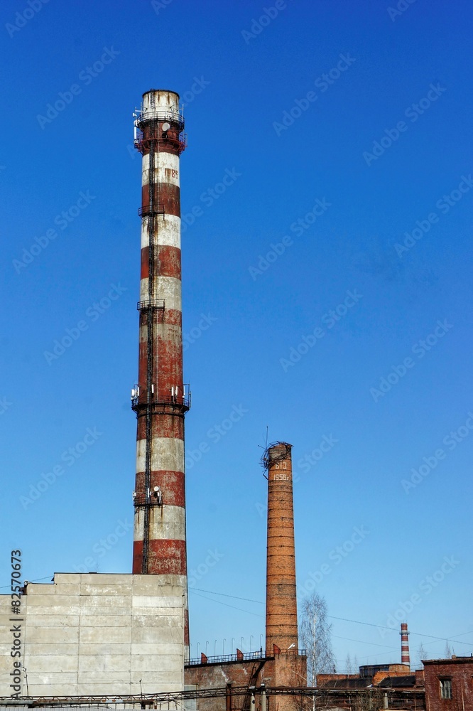 Three old factory pipes. blue sky background